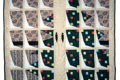 An art quilt of a christmas tree with colorful lights as seen through a set of snowy french door windows